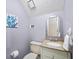 Bright half bathroom with a granite countertop, decorative mirror, and accent painting at 320 Williamsburg Cir, Mcdonough, GA 30253