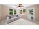 Cozy sunroom featuring a neutral-colored sofa, tiled floor, and multiple windows at 320 Williamsburg Cir, Mcdonough, GA 30253