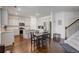 Open concept kitchen featuring hardwood floors, white cabinets and stainless steel appliances at 3236 Papyrus Palm Rd, Loganville, GA 30052