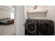 Laundry room featuring a modern washer and dryer with a shelf for storage at 3236 Papyrus Palm Rd, Loganville, GA 30052