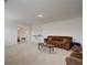 Spacious living room features neutral carpet, light walls, plus brown sofas and a wooden table at 3236 Papyrus Palm Rd, Loganville, GA 30052