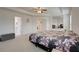 Spacious carpeted bedroom with a ceiling fan, sitting area, and multiple doorways at 3236 Papyrus Palm Rd, Loganville, GA 30052