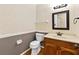 Cozy half bathroom featuring a marble vanity, decorative mirror, and neutral color scheme at 3605 Sewell Mill Rd, Marietta, GA 30062
