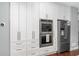 Modern kitchen featuring white cabinets, built in stainless oven and refrigerator, plus marble countertops at 44 Kingsford Xing, Acworth, GA 30101