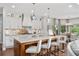 An airy kitchen with marble countertop island with seating, modern appliances, statement pendant lights and decorative backsplash at 44 Kingsford Xing, Acworth, GA 30101