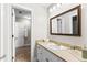 Bathroom with a single sink, decorative mirror, white cabinets, and brick-like tile flooring at 1477 Highway 85 Connector, Brooks, GA 30205