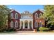Stately brick home with an elegant entrance featuring a columned portico and manicured landscaping at 1477 Highway 85 Connector, Brooks, GA 30205