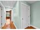 Hallway with hardwood floors and light green colored walls, with doors leading to other rooms at 1477 Highway 85 Connector, Brooks, GA 30205