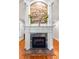Living room showcasing a fireplace with stone accents and a white mantel, complemented by hardwood floors at 1477 Highway 85 Connector, Brooks, GA 30205