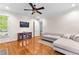 Bright living room with a ceiling fan, hardwood floors and neutral-colored sofa at 1477 Highway 85 Connector, Brooks, GA 30205