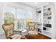 Sitting area with two ornate chairs, hardwood floors, built-in shelves, and large windows for natural light at 1477 Highway 85 Connector, Brooks, GA 30205