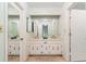 Well-lit bathroom featuring a double vanity, framed mirrors, and ample storage space at 170 Mark Nw Trl, Sandy Springs, GA 30328