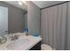 Bathroom vanity with modern fixtures, dark cabinetry, and white shower curtain at 1914 Coal Pl, Atlanta, GA 30318
