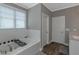 Bright bathroom featuring a soaking tub with white subway tile and wood-look tile floors at 1914 Coal Pl, Atlanta, GA 30318
