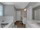 Bright bathroom featuring a soaking tub with white subway tile and wood-look tile floors at 1914 Coal Pl, Atlanta, GA 30318