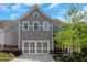 Two-story gray home with a two-car garage, landscaped yard, and a welcoming front entrance at 1914 Coal Pl, Atlanta, GA 30318