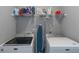 Bright laundry room with a wire shelf over two modern white washing machines, offering convenience at 1914 Coal Pl, Atlanta, GA 30318