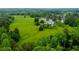 An aerial view of the property with a pond and sprawling green fields at 1415 N Flat Rock Rd, Douglasville, GA 30134