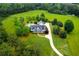 An aerial view showcasing the home, long driveway and lush lawn and landscaping at 1415 N Flat Rock Rd, Douglasville, GA 30134