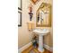 Elegant powder room featuring a pedestal sink, ornate mirror, and stylish decor at 1415 N Flat Rock Rd, Douglasville, GA 30134
