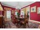 Elegant dining room with a large table, crystal chandelier, and red accent wall at 1415 N Flat Rock Rd, Douglasville, GA 30134