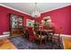 Elegant dining room with rich red walls, a crystal chandelier, and a classic wood table set for a formal meal at 1415 N Flat Rock Rd, Douglasville, GA 30134