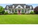 Charming two-story home featuring a welcoming front porch, classic columns, and a vibrant red front door at 1415 N Flat Rock Rd, Douglasville, GA 30134