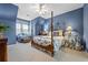 Stylish main bedroom features a four poster bed and a sitting area near a window at 1415 N Flat Rock Rd, Douglasville, GA 30134