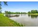 Picturesque view of a serene pond with a charming dock, set against a backdrop of lush greenery and blue skies at 1415 N Flat Rock Rd, Douglasville, GA 30134