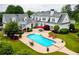 An in-ground kidney-shaped pool is set among lush landscaping and patio seating at this lovely home at 1415 N Flat Rock Rd, Douglasville, GA 30134
