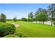 Beautifully landscaped yard featuring a brick path leading to a tranquil lake, surrounded by lush trees and greenery at 1415 N Flat Rock Rd, Douglasville, GA 30134