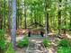 Picturesque backyard featuring a shaded bench and decorative landscaping in a serene wooded setting at 1615 Mount Mckinley Dr, Grayson, GA 30017