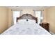 Bedroom featuring a queen bed with a decorative headboard, a side table, and natural lighting at 1615 Mount Mckinley Dr, Grayson, GA 30017