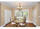 Eat-in dining room featuring a wood table with seating for four, a window with natural light, and crown molding at 1615 Mount Mckinley Dr, Grayson, GA 30017