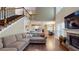 Open-concept living space with a fireplace, hardwood flooring, a staircase and seamless flow to the kitchen and dining area at 1615 Mount Mckinley Dr, Grayson, GA 30017