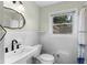 This bathroom features a white sink, toilet, and shower/tub combination with window and wood-look flooring at 1661 Barrett Nw Dr, Atlanta, GA 30318