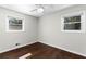 This bedroom has hardwood flooring, gray walls, a ceiling fan, and natural light from two windows at 1661 Barrett Nw Dr, Atlanta, GA 30318