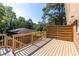 A wooden deck with stairs and railings overlooks a lush, green landscape at 1661 Barrett Nw Dr, Atlanta, GA 30318