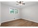 Well-lit bedroom boasts sleek hardwood floors, two windows, and a modern ceiling fan at 353 Old Rosser Rd, Stone Mountain, GA 30087