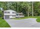 Inviting home with a two-car garage, a wide driveway, and a charming porch amidst lush greenery at 353 Old Rosser Rd, Stone Mountain, GA 30087