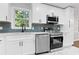 Bright kitchen features white cabinets, stainless steel appliances, blue backsplash and modern finishes at 353 Old Rosser Rd, Stone Mountain, GA 30087