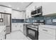 This remodeled kitchen features stainless steel appliances, white cabinetry, and modern finishes at 353 Old Rosser Rd, Stone Mountain, GA 30087