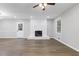 Open living room space featuring new flooring, white painted brick fireplace, and natural light at 353 Old Rosser Rd, Stone Mountain, GA 30087