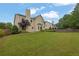 Backyard view of the house with green grass and trees at 5130 Hopewell Manor Dr, Cumming, GA 30028
