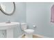 Powder room with a pedestal sink, toilet, and soft blue walls at 5130 Hopewell Manor Dr, Cumming, GA 30028