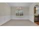 Carpeted dining room with a chandelier, wainscotting, and adjacent access to the kitchen at 5130 Hopewell Manor Dr, Cumming, GA 30028