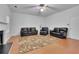 Open living room space featuring hardwood floors, a ceiling fan, and comfortable leather seating at 5130 Hopewell Manor Dr, Cumming, GA 30028