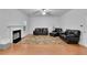 Cozy living room featuring hardwood floors, a fireplace, and comfortable leather seating at 5130 Hopewell Manor Dr, Cumming, GA 30028