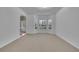 Large, carpeted living room with bright windows, and entry to the foyer at 5130 Hopewell Manor Dr, Cumming, GA 30028