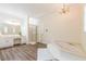 Large bathroom features a soaking tub, walk-in shower, chandelier, and double vanity at 5460 Lichenhearth Ct, Stone Mountain, GA 30087